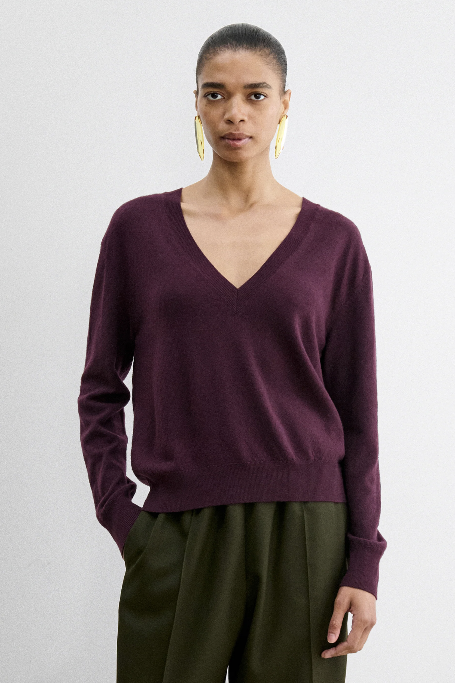 Rachel Comey Slate Pullover in burgundy styled with olive pants and gold earrings, white background.