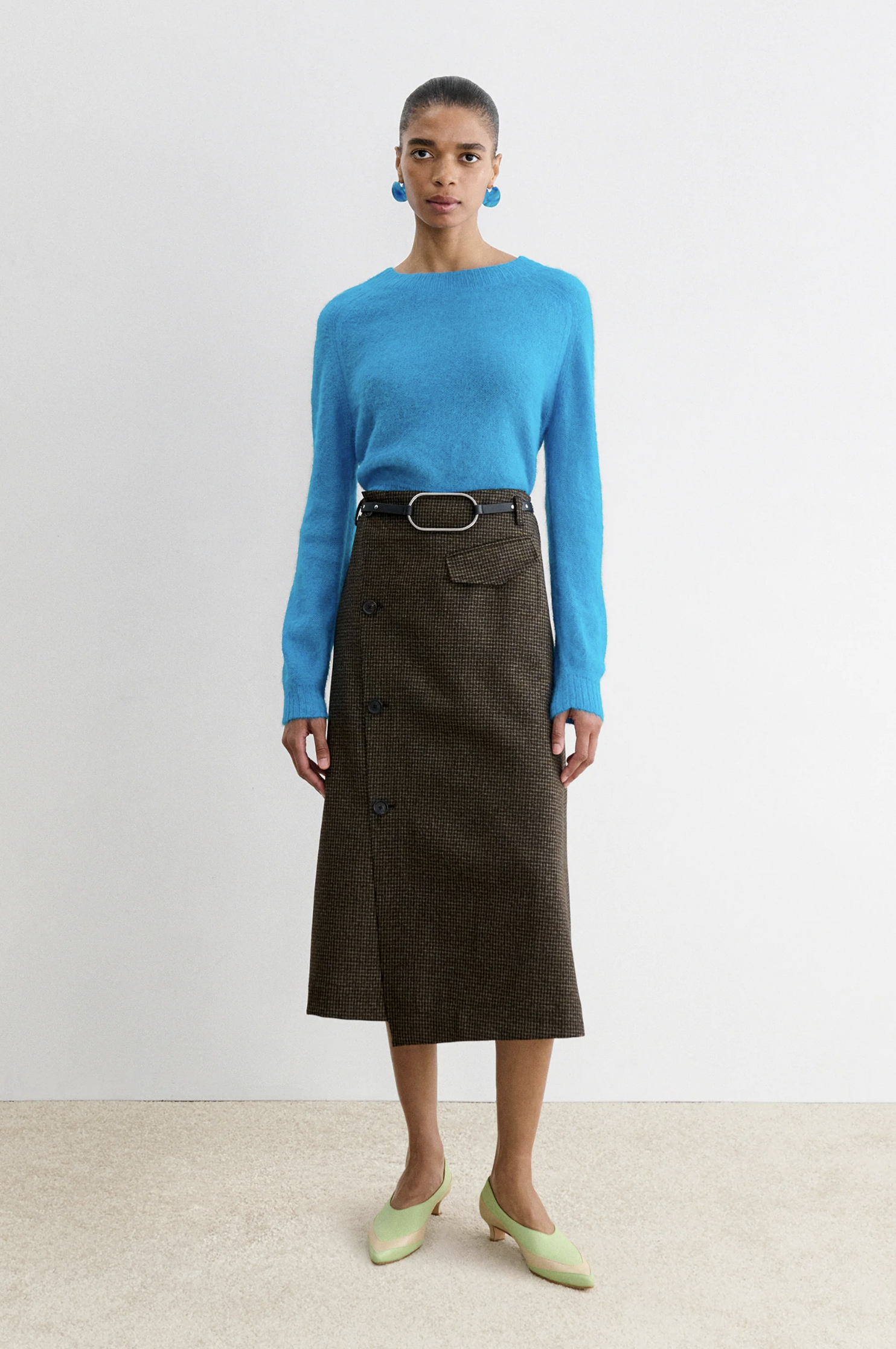 Rachel Comey Montrose Skirt in a modern style, shown on model with blue sweater and green shoes against white background.