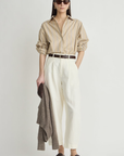 Apiece Apart Isolde Button Down styled with white pants and a brown sweater, casual modern look.