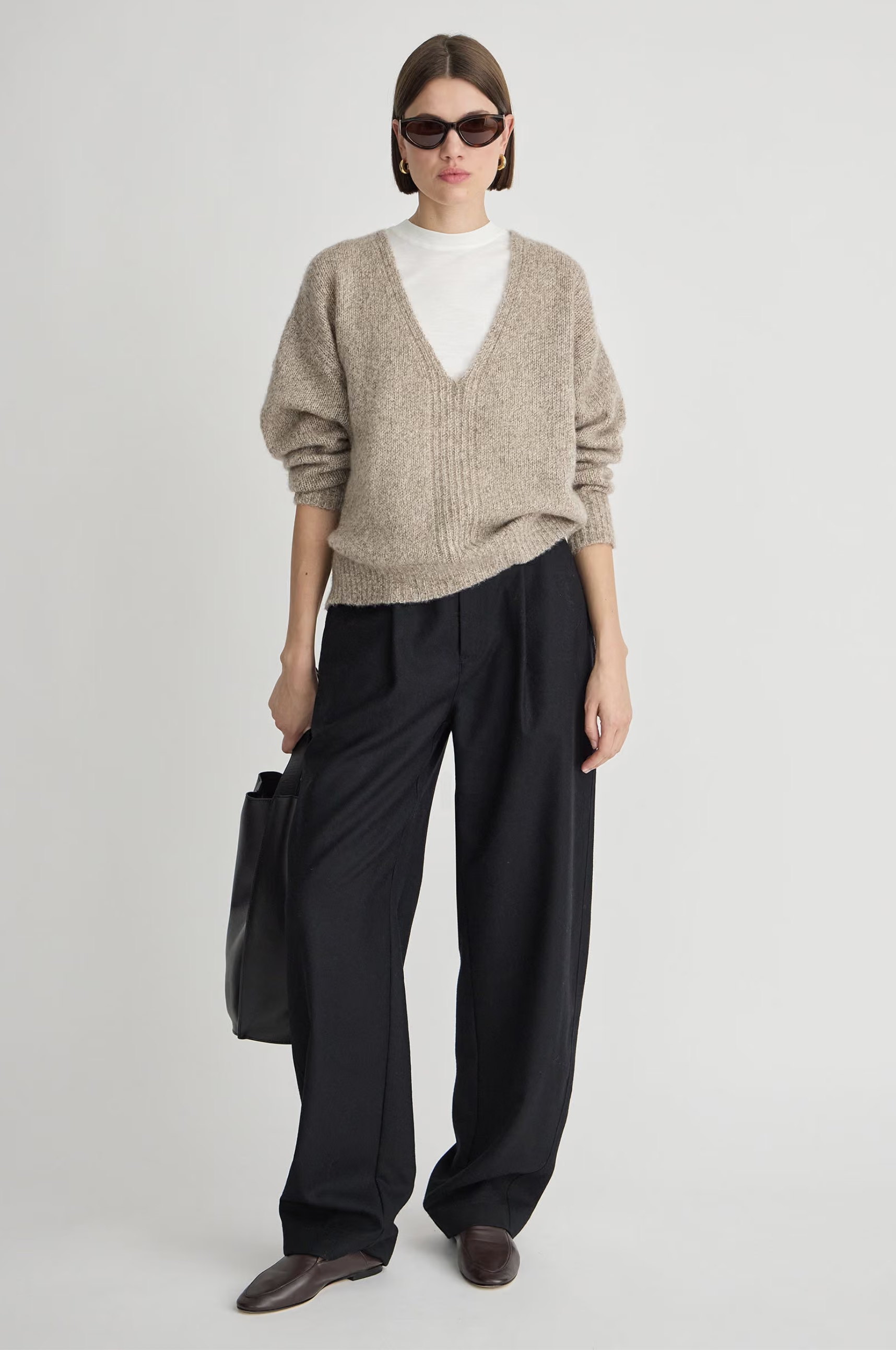 Apiece Apart Softest Silk Cashmere V-Neck Marl sweater styled with wide black pants and a black handbag.