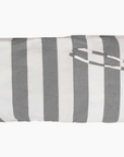 A Hedgehouse THROWBED COVER IN CHARCOAL STRIPE with wide, vertical stripes in alternating shades of gray and white. Another piece of fabric with matching stripes is draped over the pillow, creating a loop. The machine washable cover makes it versatile for both indoor and outdoor use. The pillow is set against a plain white background.