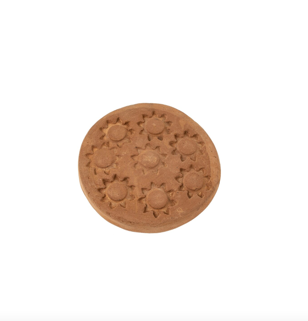 A round, brown ceramic item with an ornate sunburst pattern featuring nine sun motifs evenly spaced in a circular arrangement. Reminiscent of Southwest charm, this piece could perfectly complement a cozy bungalow in Scottsdale, Arizona. The *Sol Terracotta Coasters S/4* by *Indaba* have a flat surface and are set on a plain white background.