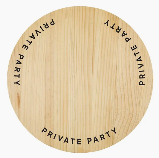 A Picnic Basket - Private Party by Faire with the words "PRIVATE PARTY" written multiple times around the outer edge in black text. The board, reminiscent of a relaxed bungalow vibe, has a light, natural wood texture and color, perfect for adding some charm to events in Scottsdale, Arizona.