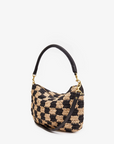 The Petite Moyen S24 by Clare Vivier is a black and beige woven handbag featuring a checkered pattern with a sleek black leather strap. Its handwoven design, reminiscent of a mini messenger style, stands elegantly against a plain white background.