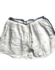 A pair of white, cotton Hawaiian Beach Shorts from By the Sea Organics with an elastic waistband and a drawstring waist. The shorts have a wrinkled texture and are laid flat against a plain white background.