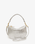 The Petite Moyen S24 by Clare Vivier showcases versatile style with its silver woven handbag design, featuring a short handle and crossbody straps. The metallic surface mimicking handwoven leather boasts a basket-like texture and is accentuated by gold-tone hardware, set against a plain white background.