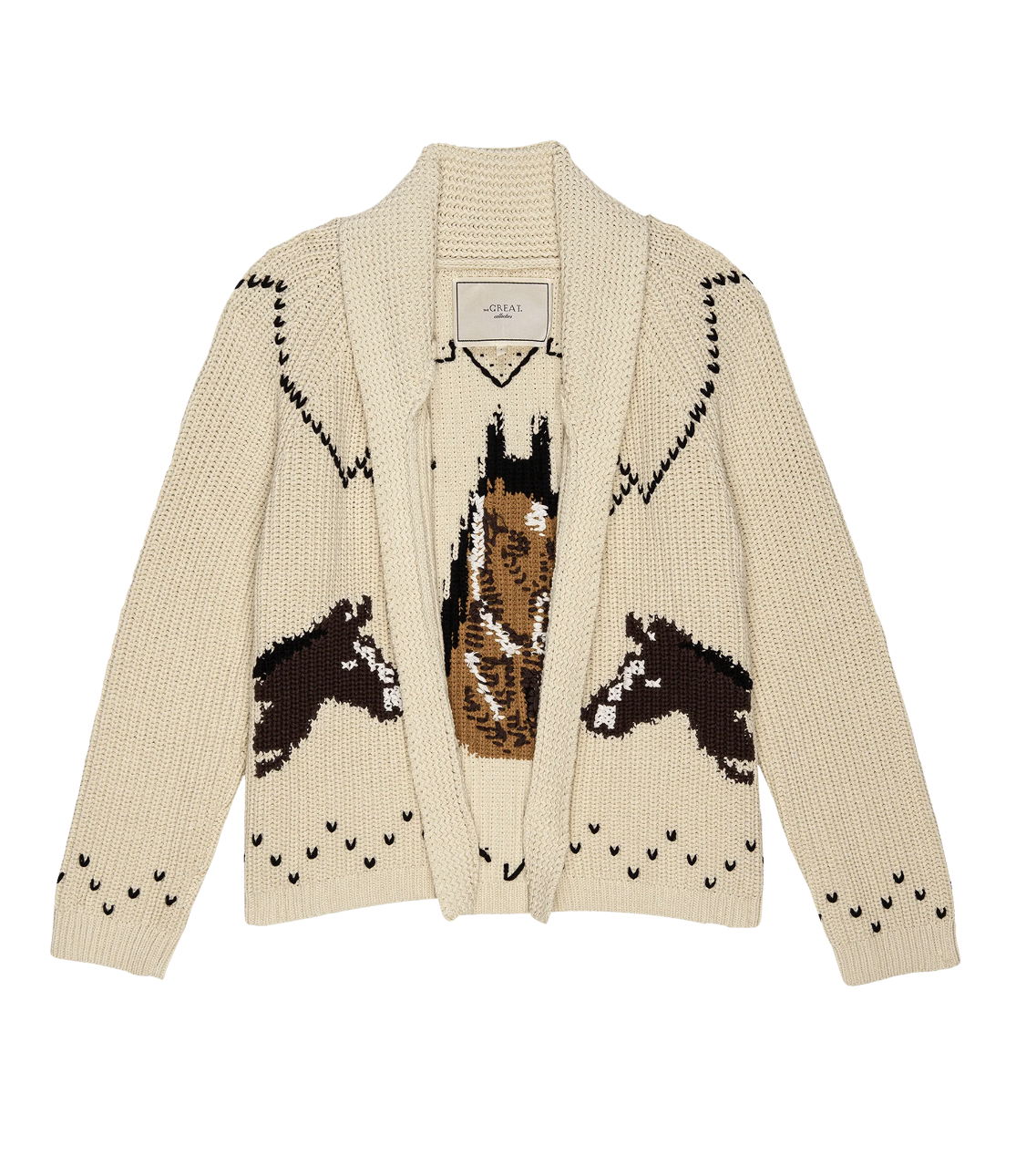 The Horse Lodge Cardigan by The Great Inc. is a cream-colored, knitted piece with a shawl collar. It features an exquisite design of three hand-embroidered brown and white horses on the front and has a textured, cozy appearance accented with black detailing around the shoulders and hem.