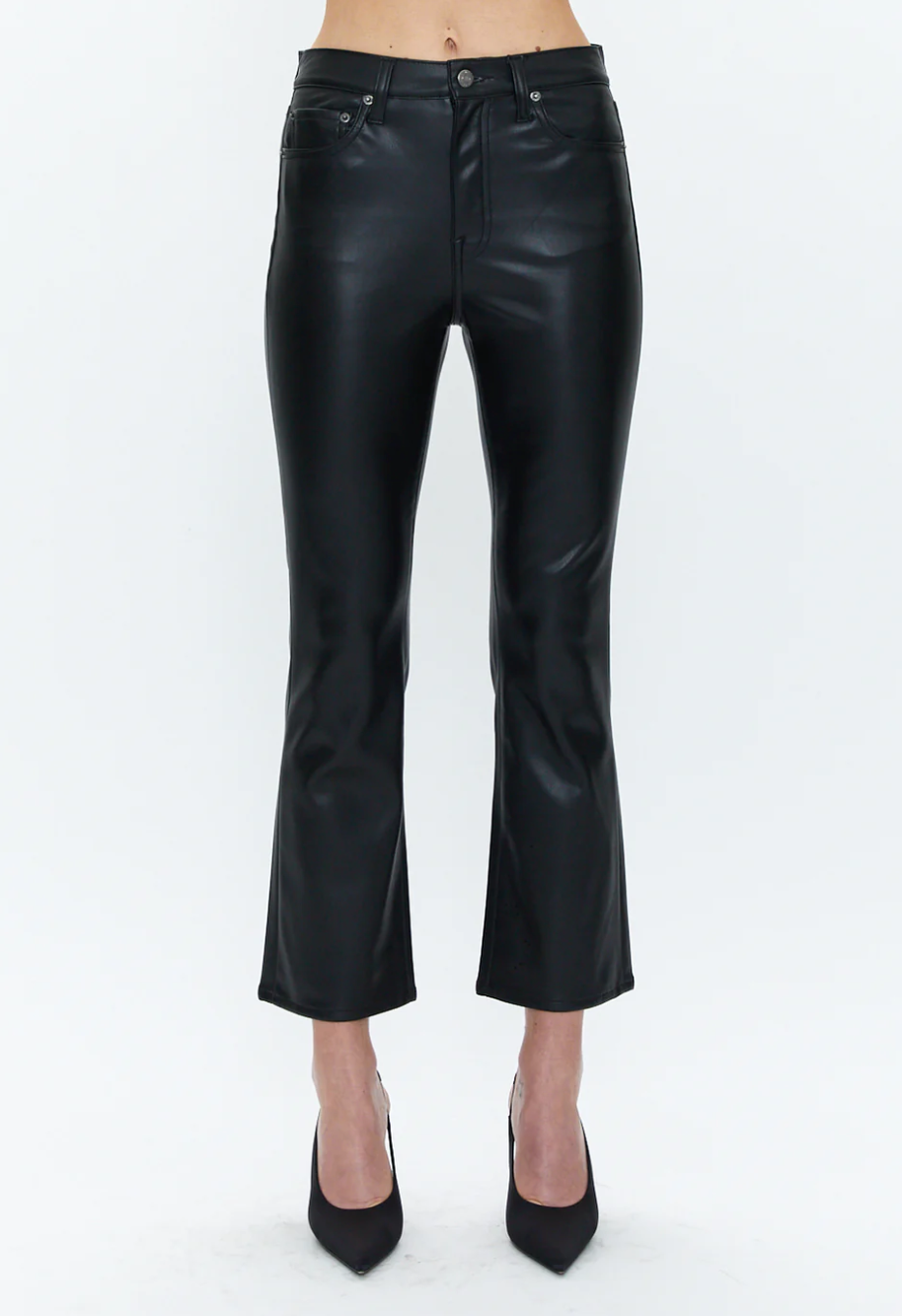 A person is wearing buttery soft, black, high-waisted Lennon Pants by Pistola with a slightly flared cut and black pointed-toe heels. The background is plain white, and only the lower half of the body is shown.