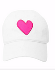 Introducing the Kerri Rosenthal Imperfect Heart Hat: a white baseball cap crafted from stone-washed cotton, boasting a relaxed fit and classic curved brim. Its standout feature is a large, vibrant pink Imperfect Heart patch embroidered prominently in the center.