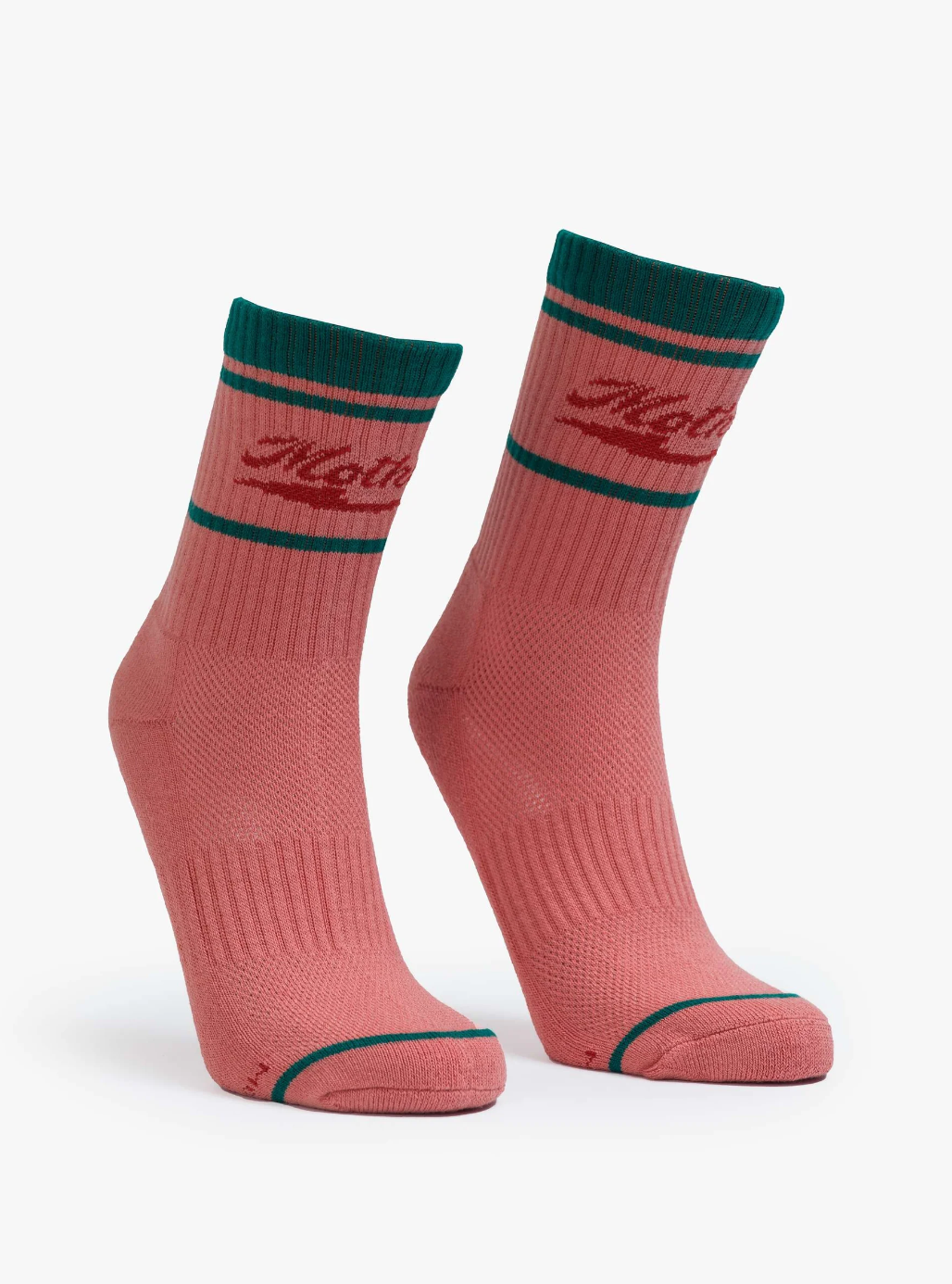 Two pink "Baby Steps" tube socks by Mother, featuring dark green accents and a red logo near the top, styled like a Rodeo Queen's. The socks are displayed standing upright on a white background.