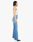 A person with a bob haircut is wearing a white sleeveless top and the Lil HW Weekender Fray flare jeans by Mother in a medium blue wash, paired with black pointed shoes, standing in profile against a white background.