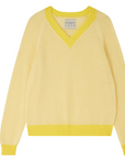 The Holey Contrast Vee by Jumper 1 2 3 4/CR2 is a yellow cashmere jumper with a V-neck, long sleeves, and brighter yellow trim on the collar, cuffs, and hem. It features an oversized fit with a textured, airy weave.