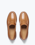 The ELBA Loafer from Freda Salvador is a pair of handcrafted brown leather shoes with a polished finish and moc toe design. They feature a penny loafer strap, visible insoles with printed text, and are displayed against a white background.