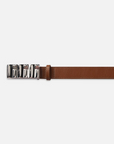 The Sculptural Belt by FRAME is a brown leather belt with a shiny silver ridged bar buckle featuring an abstract interlocking design, displayed prominently on the left of a plain white background.