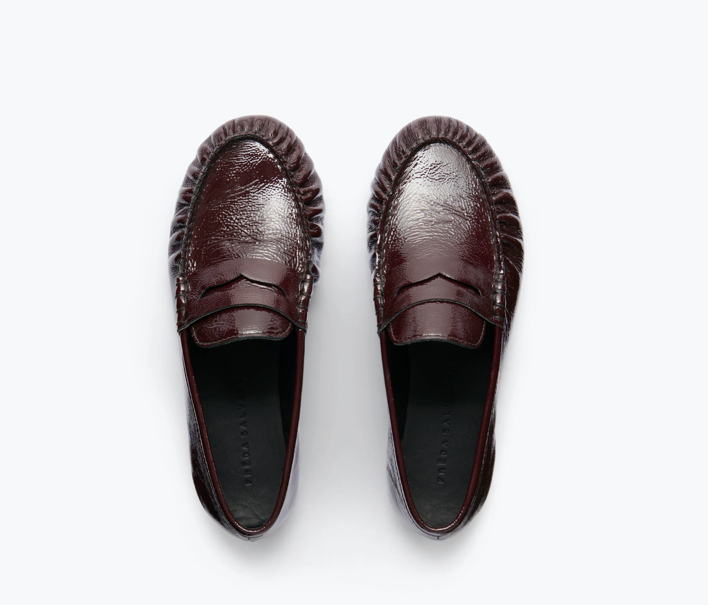 The Freda Salvador Sydney Crinkle Loafer is a shiny, dark brown Italian leather penny loafer with textured edge detailing, shown from above against a light, neutral background.