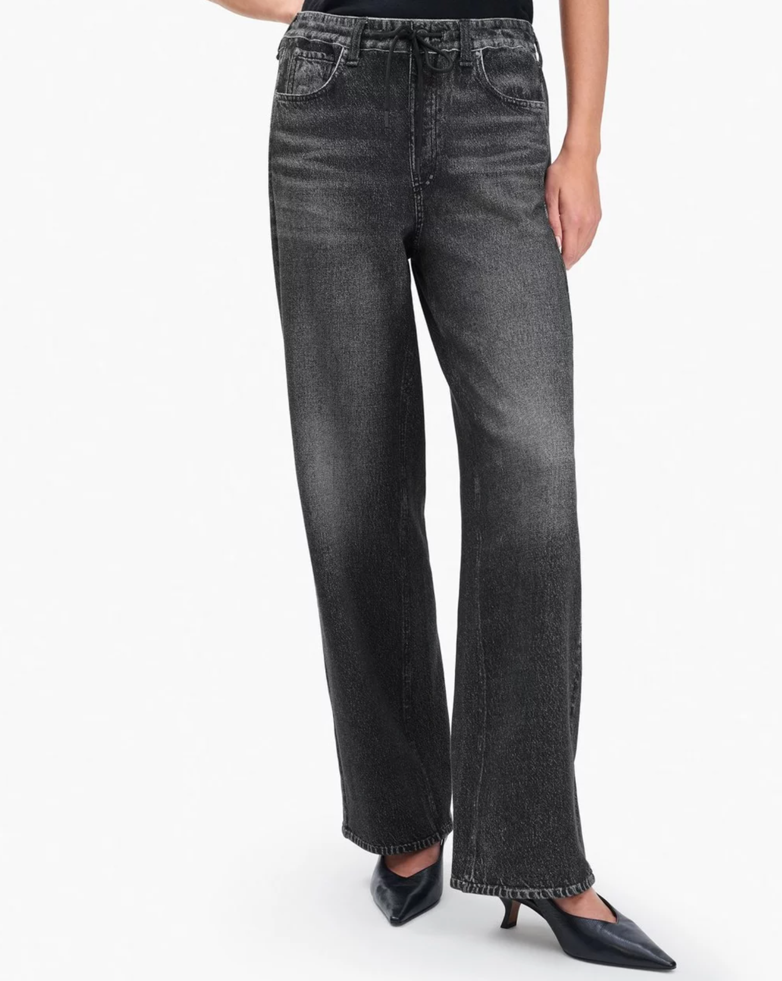 A person wears Rag & Bone's Miramar Drawstring Wide-Leg Pants in black with an elastic waist and black pointed-toe heels, shown from waist to feet against a plain white background.