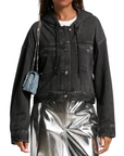 A woman wears a Rag & Bone miramar terry hood trckr jckt, styled with silver metallic pants and a small blue shoulder bag. The jacket features button closures and chest pockets for classic appeal.