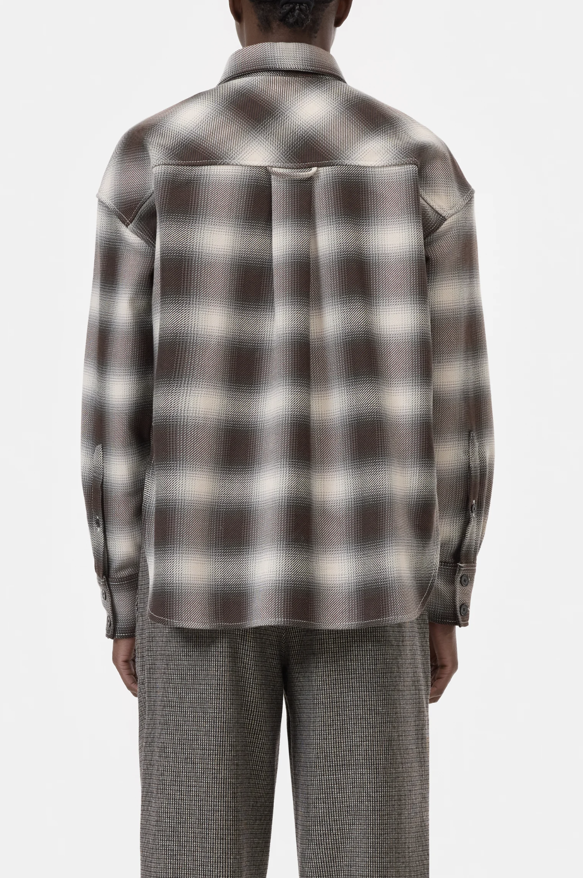 A person is seen from the back, wearing the CLOSED Cropped Front OS Shirt—a long-sleeve brown and white cotton checkered shirt with a chest pocket—paired with gray checkered pants against a plain white background.