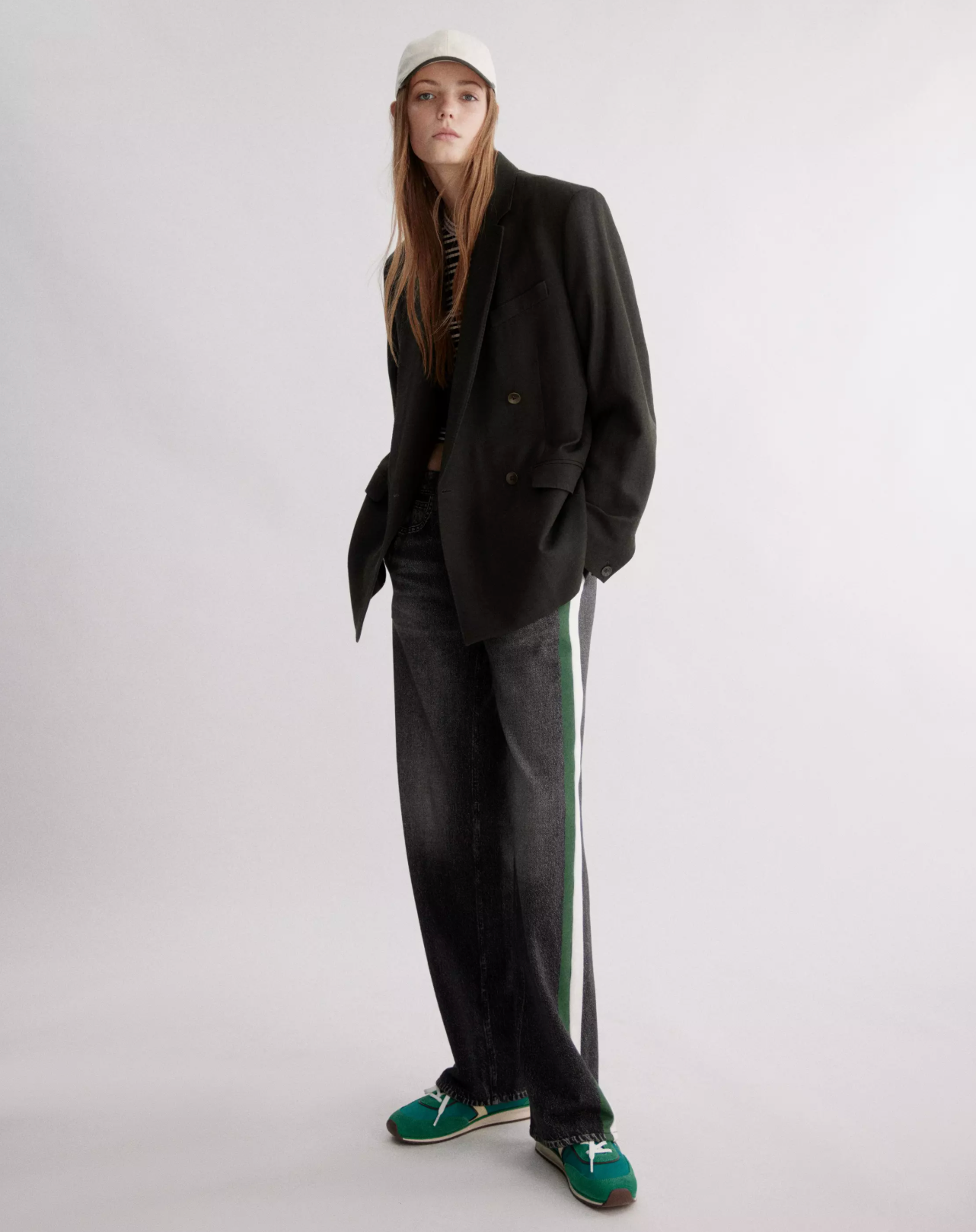 A person in a gray cap, oversized black blazer, black shirt, and Rag & Bone miramar terry track pant pull on stands against a plain light background.
