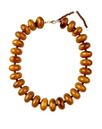 The Faire Bailey Chunky Beaded Necklace features large, glossy amber-brown beads strung closely together and includes an adjustable clasp with a small extension chain.