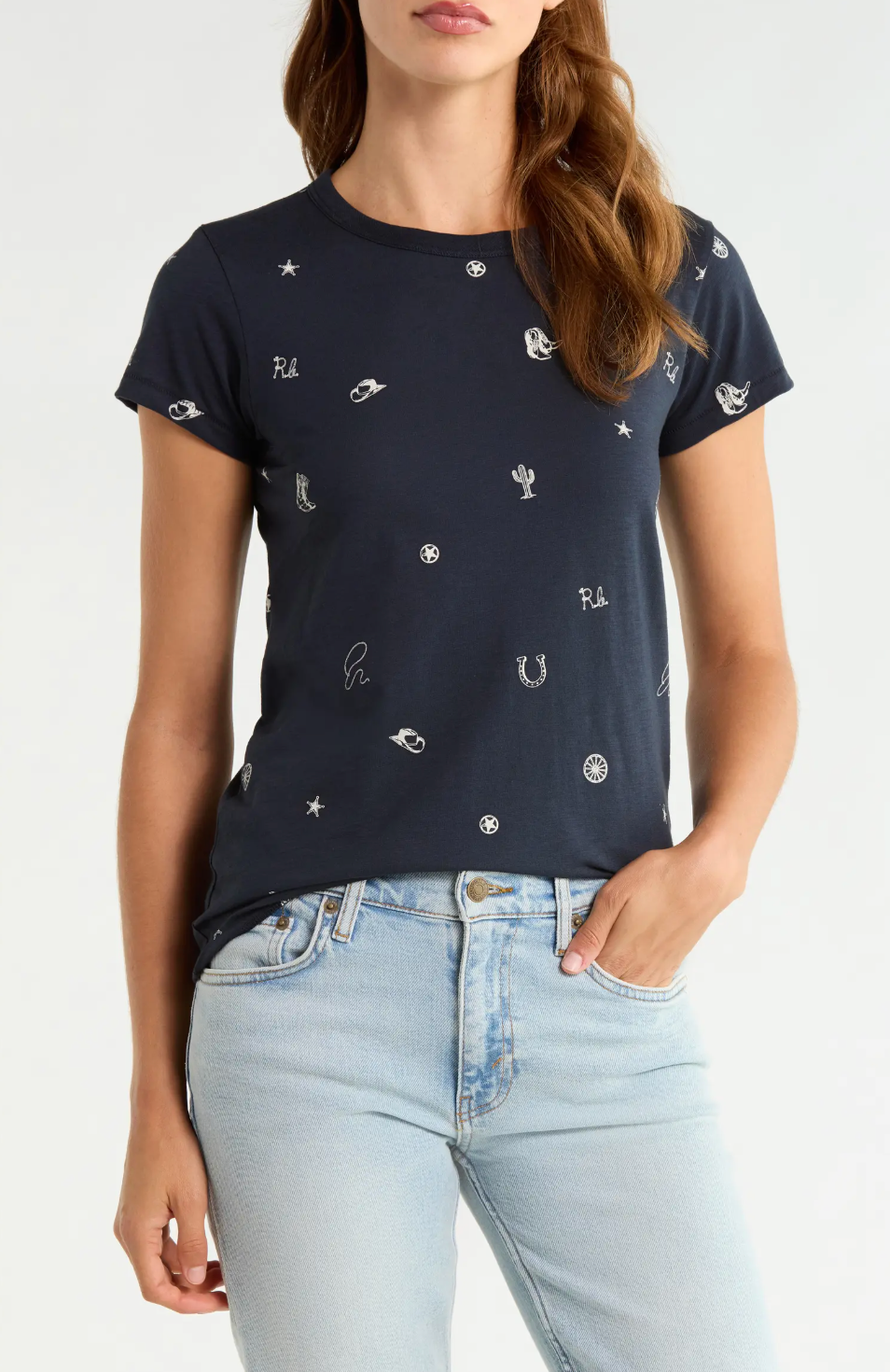Rag &amp; Bone rodeo graphic tee in white paired with light blue jeans, casual hand-in-pocket look.
