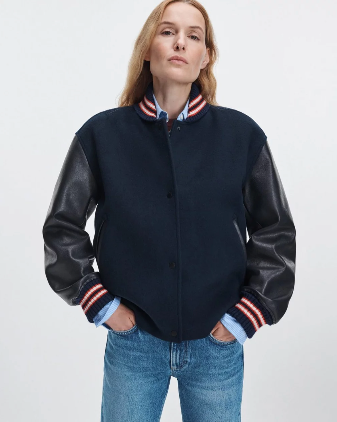 Rag &amp; Bone Scarlet Varsity jacket with faux leather sleeves styled with blue jeans, hands in pockets.