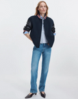 Scarlet Rag & Bone varsity jacket with striped shirt, blue jeans, and black shoes in a casual outfit setting.