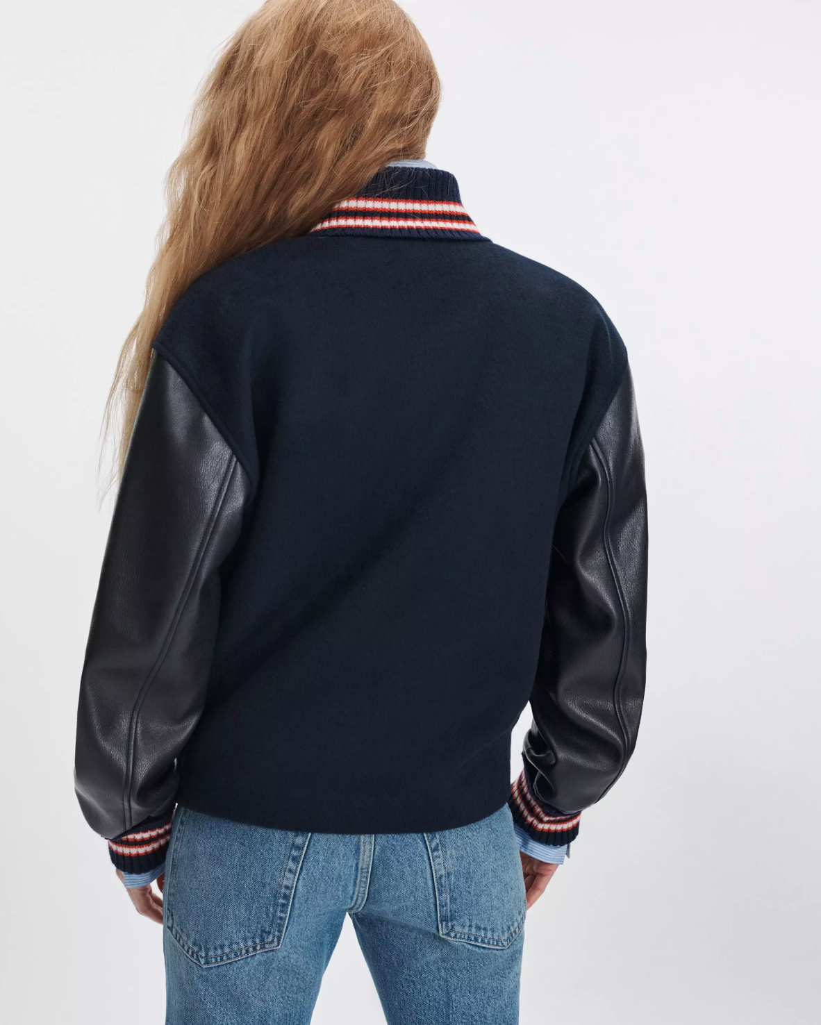 Scarlet varsity jacket with faux leather sleeves by Rag &amp; Bone, shown from the back with blue jeans.