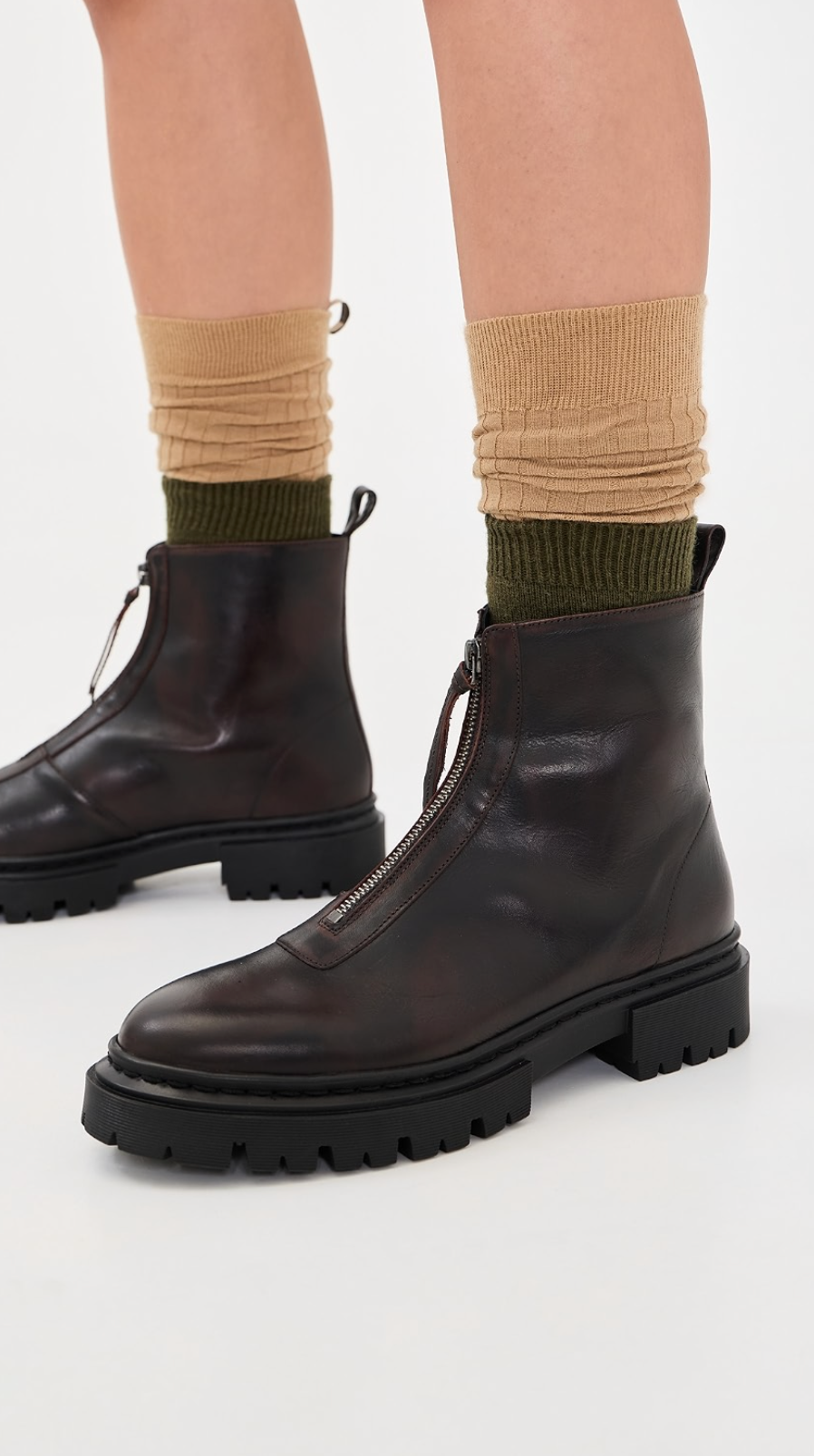 Brown Staud Miles Zip Ankle Boots with chunky soles, styled with green and tan socks on a white background.