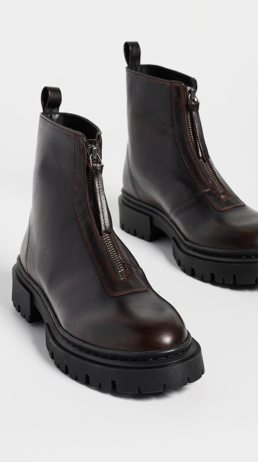 Dark brown leather ankle boots with chunky soles and front zippers by Staud, Miles Zip style.