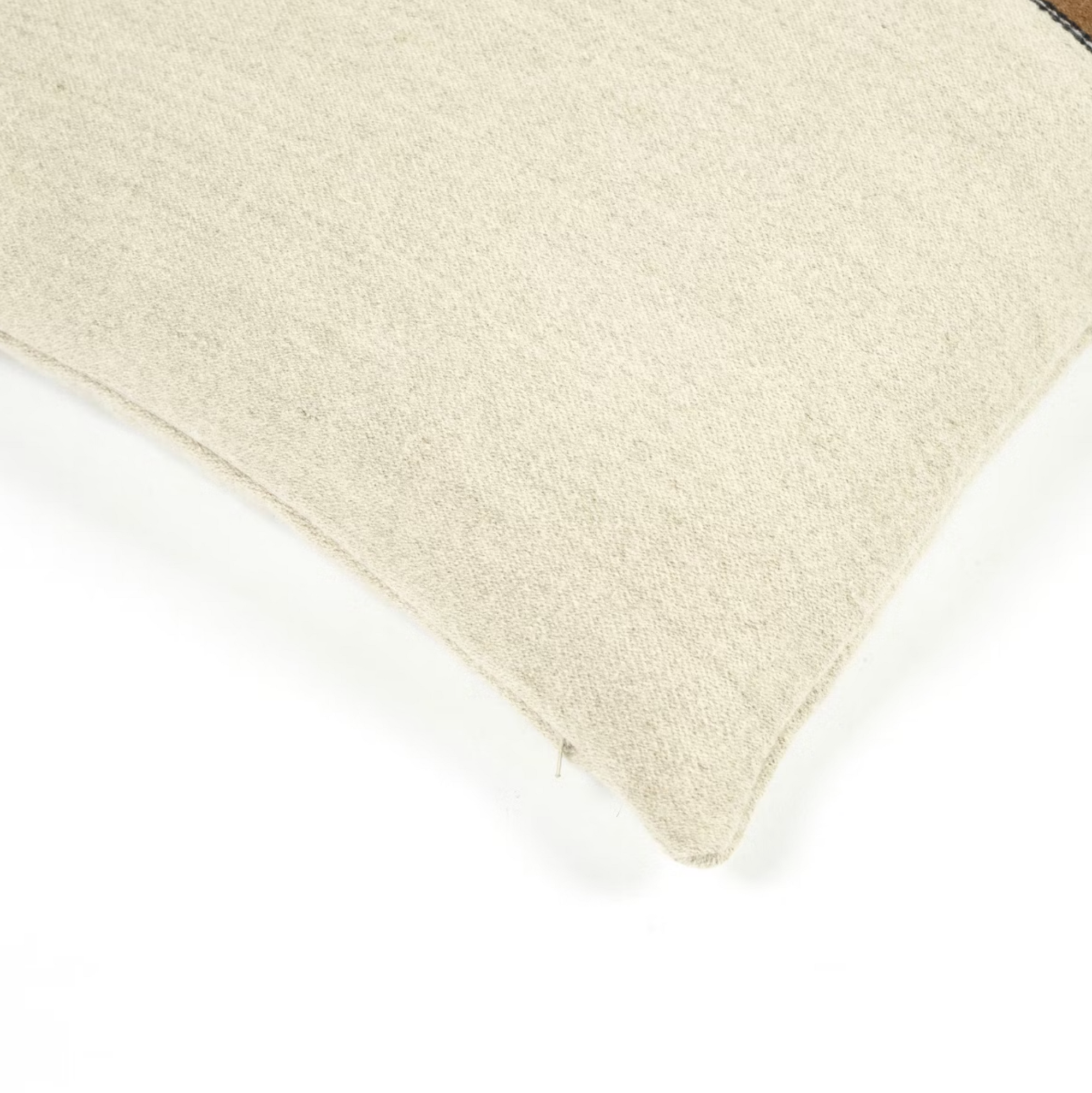 Close-up of the corner of the Gus Pillow by Libeco Home in beige fabric against a white background, showcasing its textured surface and stitched seam.