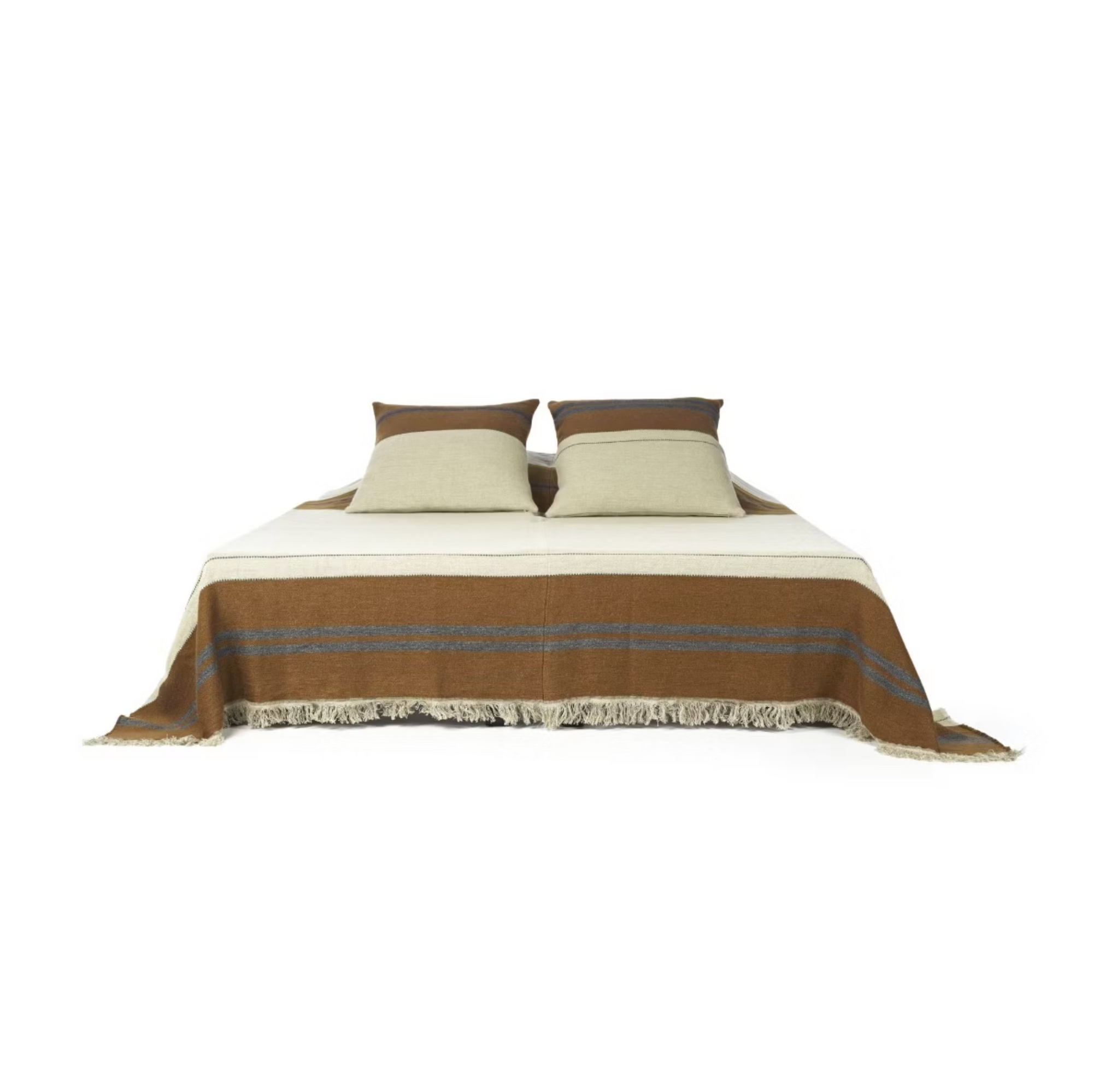 A neatly made bed featuring The Highland Coverlet by Libeco Home from the linen/wool collection, paired with two beige pillows and a brown fringed blanket, set against a white background.