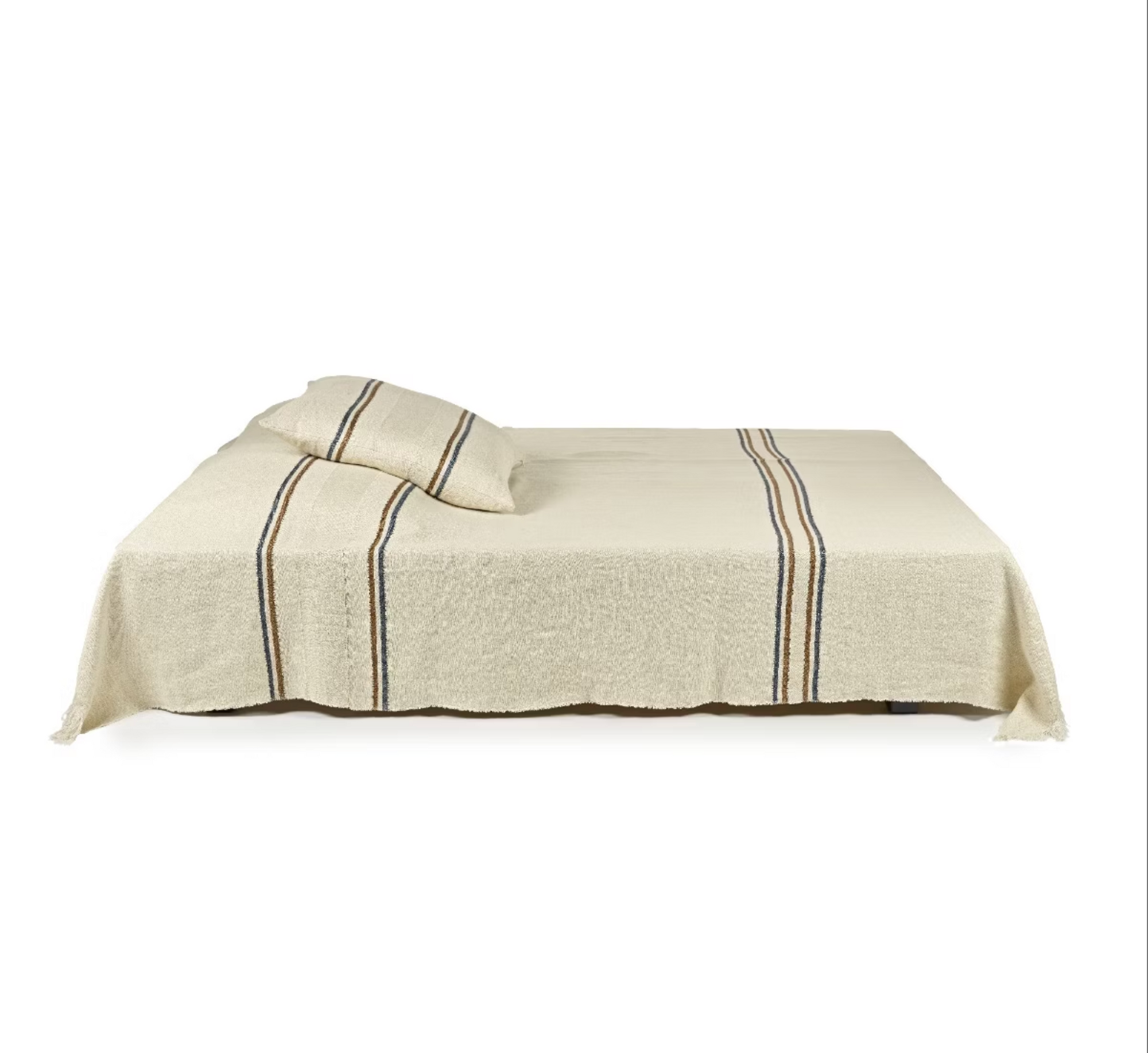 A neatly made bed features the Libeco Home Auburn Coverlet and matching pillow, both in cream with dark and light vertical stripes, against a plain white background.
