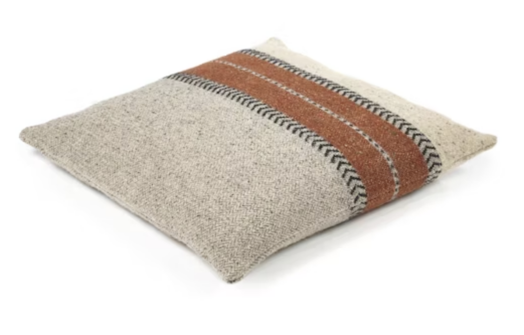 The Montana Pillow by Libeco Home is a square beige throw pillow featuring two wide rust stripes bordered by black herringbone zigzags—perfect for adding a cozy, rustic winter touch to your space.