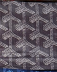 A close-up of a Faire Reusable Shopping Bag, featuring a rectangular shape and a repeating geometric pattern of interlocking Y-shaped motifs in gray and black tones.