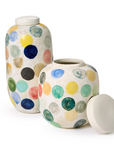 Two's Company Colorful Circle Dot Vases, with off-white lids and vibrant polka dots in blue, green, yellow, orange, and red, sit on a white surface. One vase’s lid is removed and placed beside it.