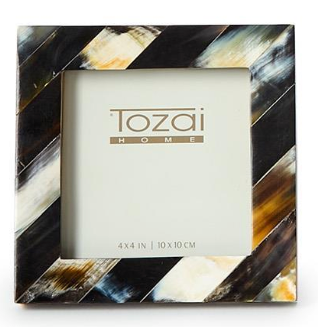 The Black Horn Photo Frame by Two's Company is a square, handcrafted frame with diagonal black, white, brown, and golden-yellow stripes. It features a luxury 4 x 4 inch (10 x 10 cm) display for your photos.