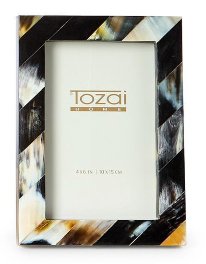 The Black Horn Photo Frame by Two's Company is a rectangular luxury frame with diagonal black, brown, cream, and white stripes. This handcrafted photo frame fits a 4x6 in (10x15 cm) photo and features an elegant blank display.