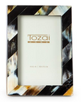 The Black Horn Photo Frame by Two's Company is a rectangular luxury frame with diagonal black, brown, cream, and white stripes. This handcrafted photo frame fits a 4x6 in (10x15 cm) photo and features an elegant blank display.