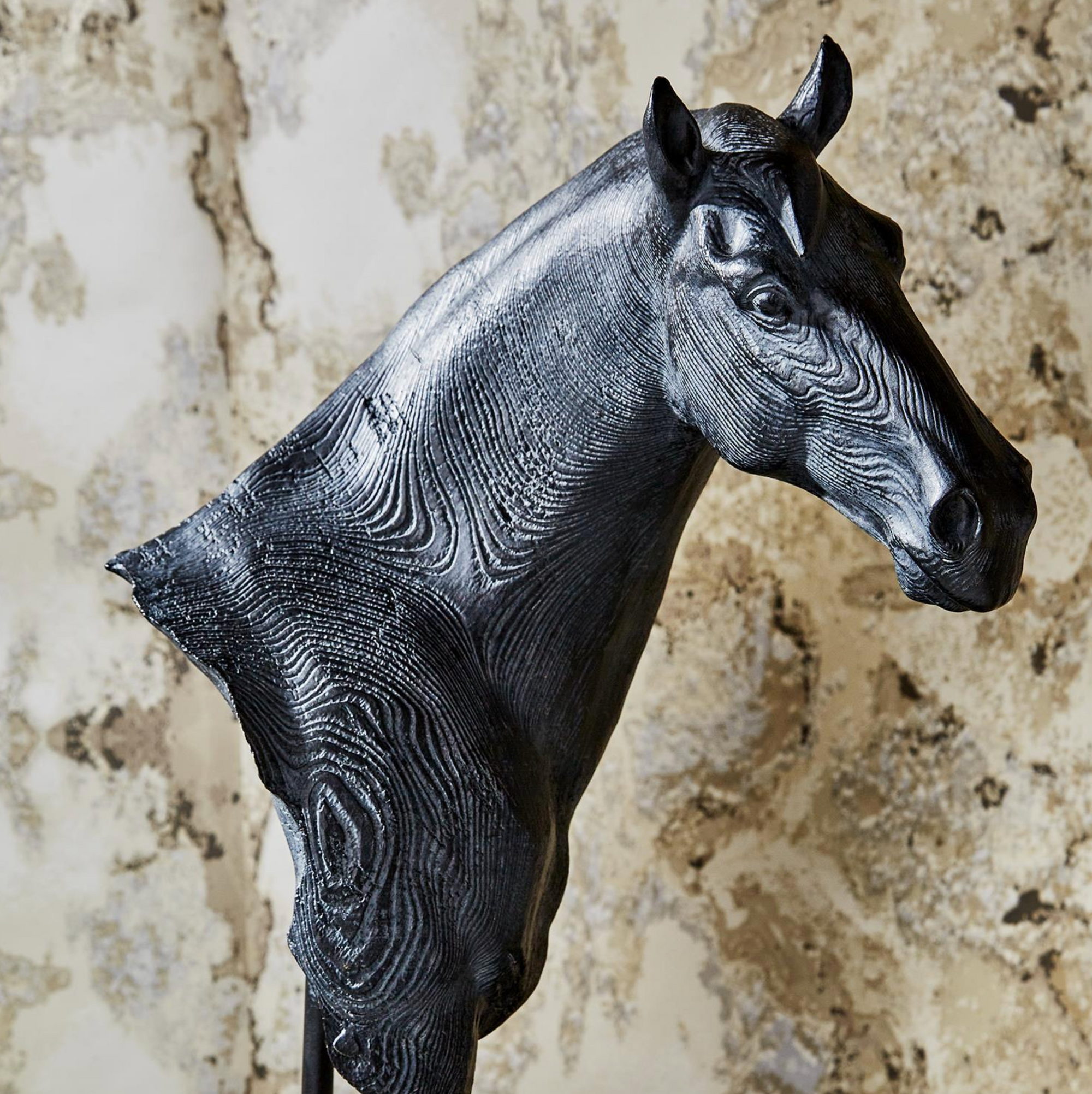 The Horse Bust Sculpture by Two's Company features a textured black finish with faux wood grain, detailed facial features, and a rustic look—perfect for adding character to your home decor against any light background.