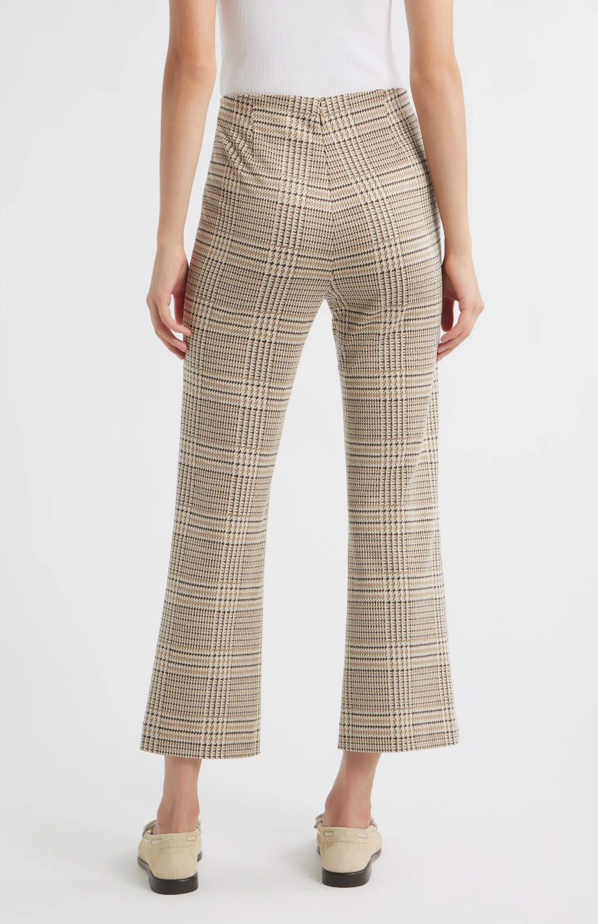 A person stands with their back to the camera in Rag & Bone's irina ponte kick flare pants, featuring a beige and brown plaid pattern, paired with off-white loafers against a plain white background.