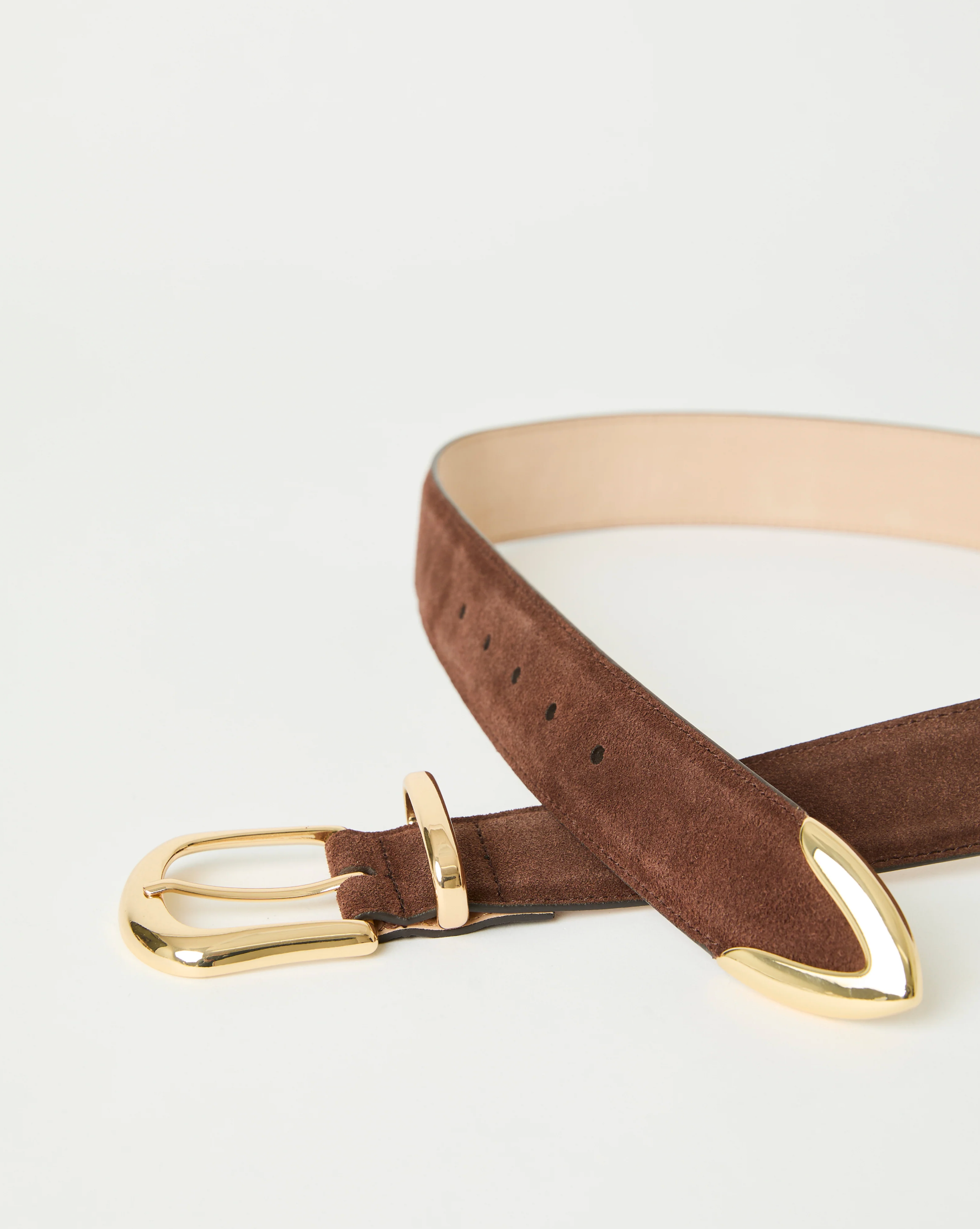 The Marc Belt by B-Low The Belt is a brown suede calfskin hip belt with gold-tone hardware, including a gold buckle and gold-tipped end, shown on a white background.