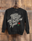 The Madeworn Shrunken Sweatshirt by Made Worn, crafted from heavyweight cotton, showcases "Willie and Family on the Road Again" in white retro font with a red rose graphic, hanging on a wooden hanger against a rustic wooden wall.