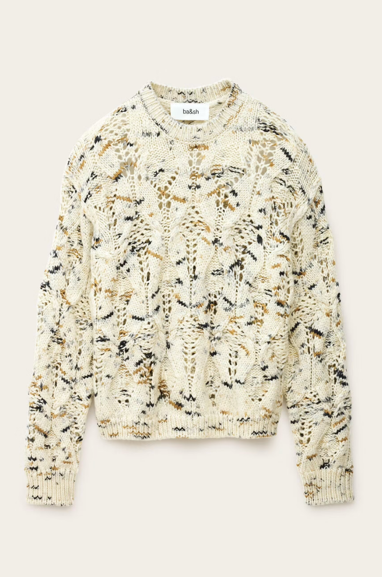 The BA&SH Jumper Rave is a cream, chunky 100% wool sweater with a loose fit and abstract black, brown, and tan speckles. Shown flat on a neutral background. Hand wash or dry clean only.