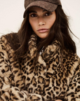 A woman wears the BA&SH Coat Jaros Leopard, crafted from polyester—perfect for stylish outings and labeled dry clean only for effortless care.