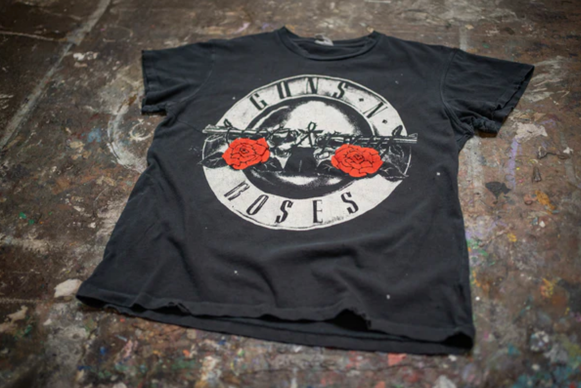 The Made Worn Guns N Roses Crew Tee is a black shirt featuring the band's classic logo with two red roses and crossed guns in a circle—perfect for "Welcome to The Jungle" fans.