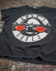 The Made Worn Guns N Roses Crew Tee is a black shirt featuring the band's classic logo with two red roses and crossed guns in a circle—perfect for "Welcome to The Jungle" fans.