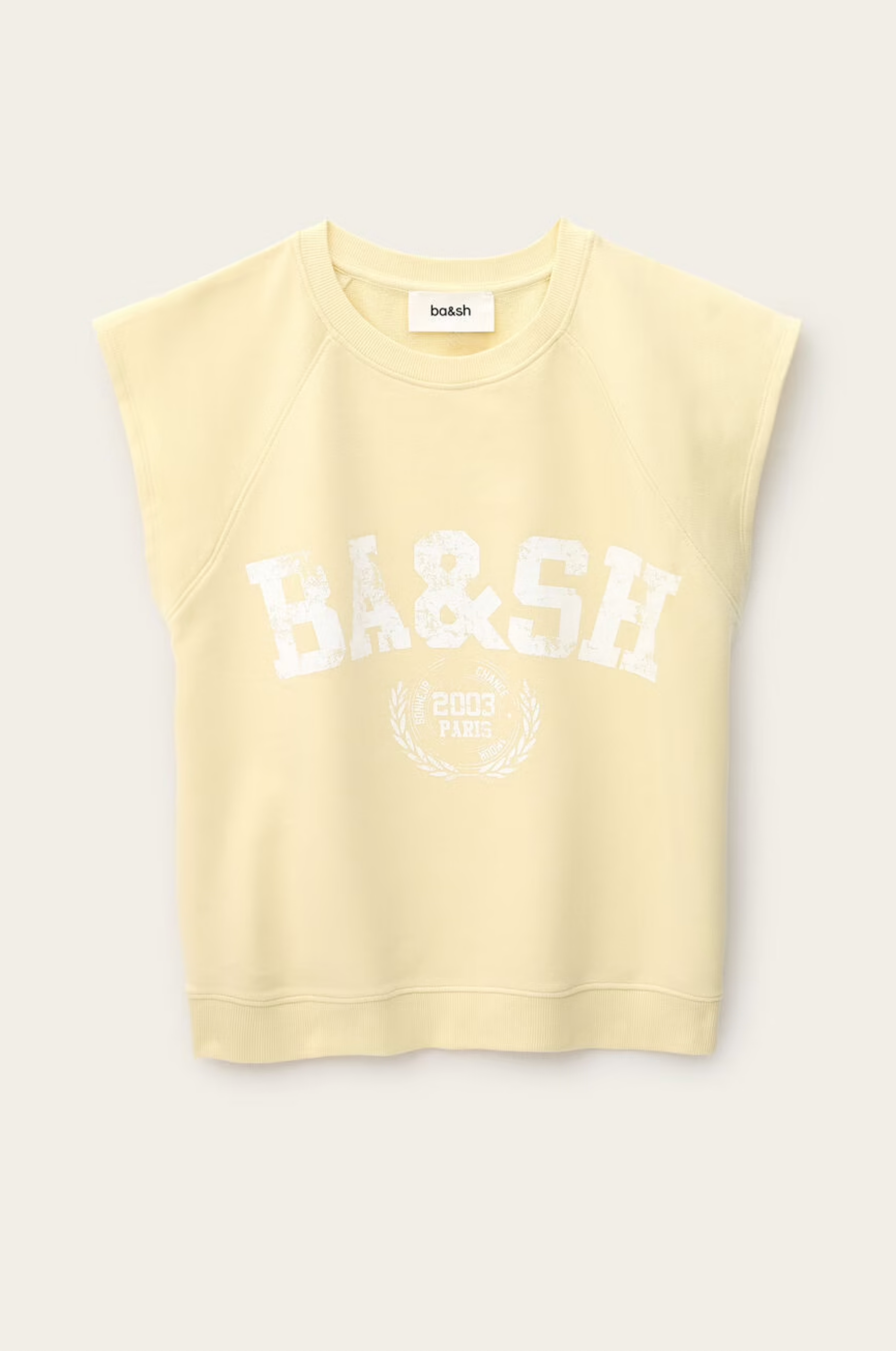 The BA&SH Sweat Benta is a sleeveless, light yellow sweatshirt with raglan armholes, a round neckline, and "BA&SH 2003 PARIS" text with a laurel graphic on the front.