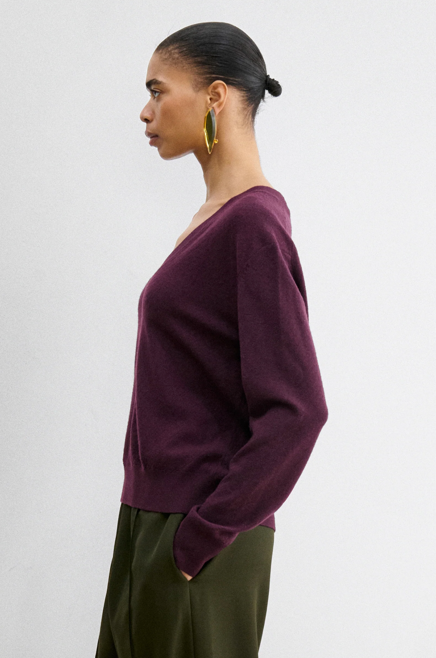 Rachel Comey Slate Pullover in blue paired with olive pants, styled with gold hoop earrings for a chic look.