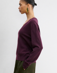 Rachel Comey Slate Pullover in blue paired with olive pants, styled with gold hoop earrings for a chic look.